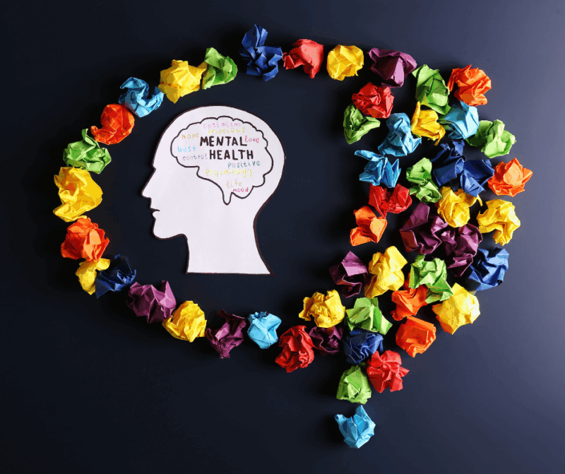 Head with the label mental health written in the brain cavity inside a colourful speech bubble.